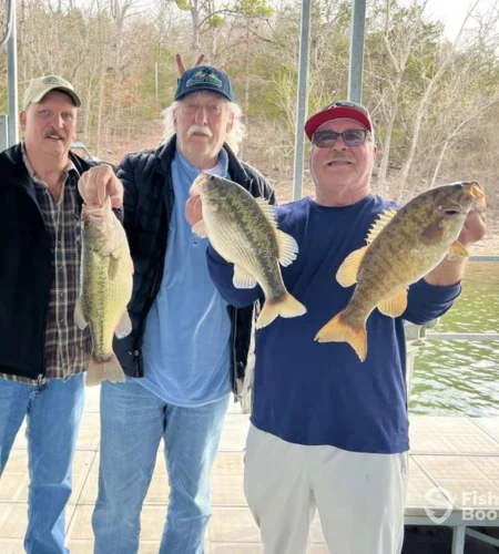 Three anglers showing bass catch after a guided fishing trip